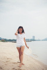 Portrait of young woman walking on the beach barefoot.