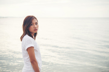 Young woman standing on the beach.