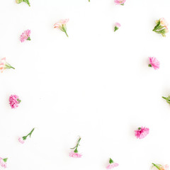 Frame with pink and beige wildflower buds, green leaves, branches on white background. Flat lay, top view. Valentine's background