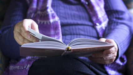 Naklejka premium Old Woman Reading A Book At Home 
