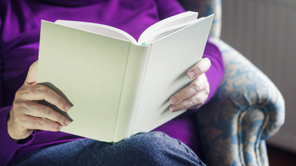 Fototapeta premium Old Woman Reading Book At Home