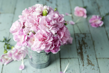 Naklejka na ściany i meble Pink carnation flowers in zinc bucket on vintage wood