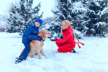 Fototapeta na wymiar happy family with dog in winter park