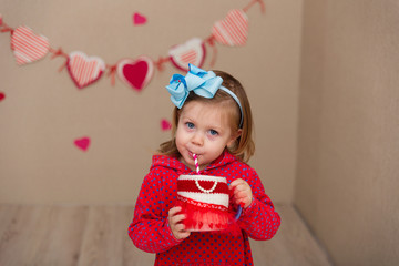 Little cute girl on the background wall of a house