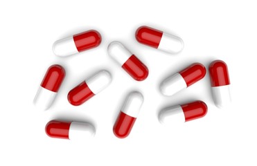 Overhead view of many red and white drug capsules isolated on white background