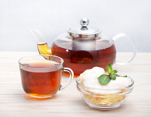 Пирожное на тарелке и чашка натурального заварного чая.