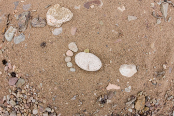 trace feet made of a pebble stone close up on the sea sand deser
