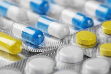Boxes with white-blue medical pills and yellow pills