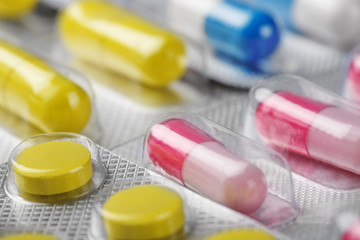 Boxes with red medical pills and yellow pills