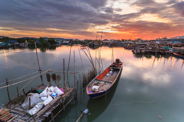 Fototapeta premium Fishing boat in harbor with sunrise 
