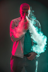 Men with beard  in sunglasses vaping and releases a cloud of vapor.Men with beard  in sunglasses vaping and releases a cloud of vapor.