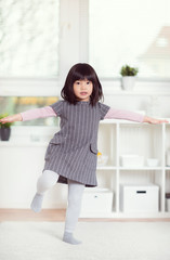 Portrait of cute little japanese girl lying on wite carpet