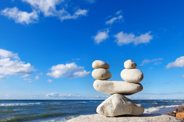concept of balance between work and life. Balance stones against the sea. Rock zen in the form of...