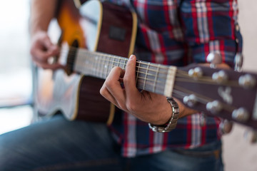 Accord chord, Close up of mens hands playing an acoustic guitar