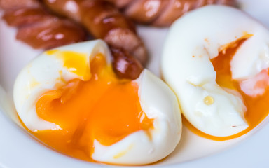 closeup sausage with boil eggs in white dish