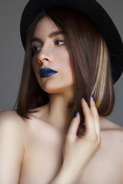 Portrait of beautiful young woman with blue lips and in hat. Bea