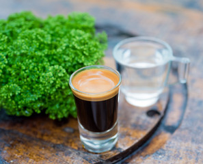 Espresso coffee cup serve with glass of water on wooden table