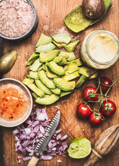 Cut avocado with knife and Healthy cooking ingredients for tasty salad or dip , top view