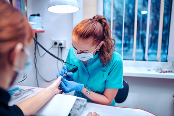 Manicure process in beauty salon close up of female hands