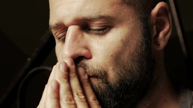 young man praying for his sick mother