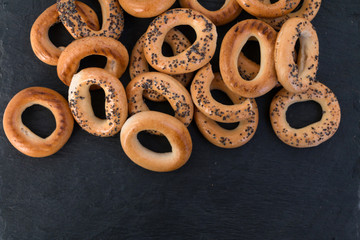 Bread poppy seed bagels on a black slate, Russian sushki, simple