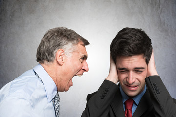 Angry businessman shouting to an employee