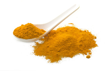 dust of ground turmeric on the spoon