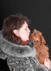 woman holds a small shaggy puppy