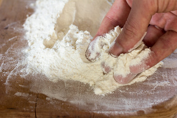 male fingers trying to touch the flour, close-up