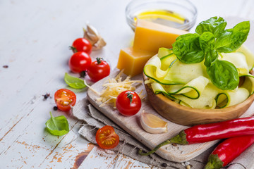 Raw zucchini pasta and ingredients