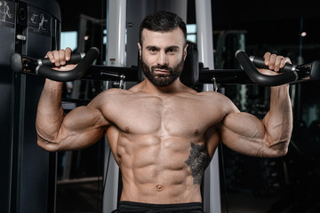 Fototapeta na wymiar Fitness instructor handsome man in the gym gain muscle