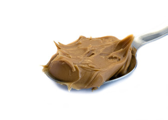 Erdnussbutter auf Löffel isoliert auf weiß