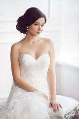 Fototapeta na wymiar Bride in beautiful dress sitting on chair indoors