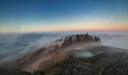Top of Hill in Fog with View over Frosty Countryside Fields in UK