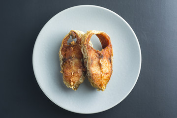 Fried Seabass fish on black background.