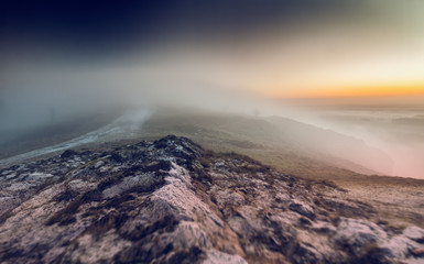Fototapeta na wymiar Frosty Hill Capped in Morning Fog and Dawning Sky
