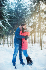 woman and man having fun in winter forest