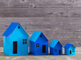 A paper houses stands over a wooden background