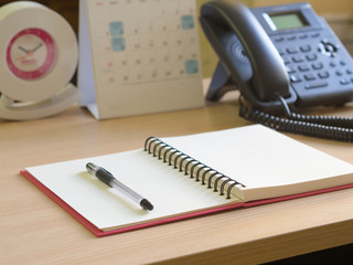 Notebook, pen, and phone on the desk . The operator concept.