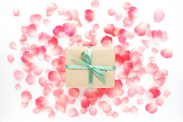 Gift box in kraft paper on background with petals