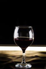 glass of red wine on a black background backlit