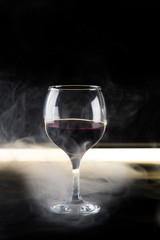 glass of red wine on a black background backlit
