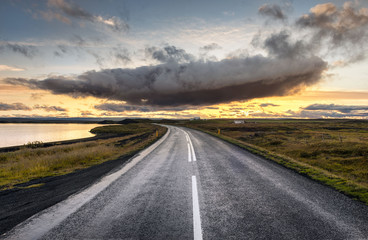 Obraz na płótnie Canvas Myvatn, Iceland - dramatic cloud above empty road into sunset