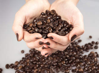 Close Up of Roasted Coffee Beans and Female Hand Full of seeds