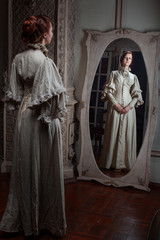 Naklejka premium The woman looks in the mirror, retro image.