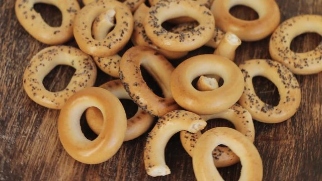 Bread poppy seed bagels on a wooden desk, Russian sushki, simple dessert for tea ceremony and beer party. Slow rotation.