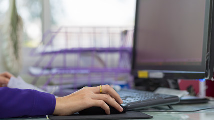 Woman's hand holding a mouse for office work.