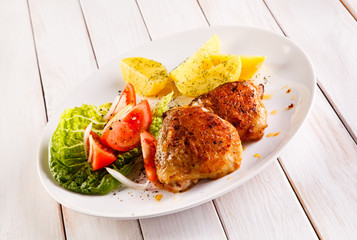 Grilled chicken thighs with boiled potatoes and vegetable salad 