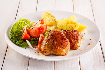 Grilled chicken thighs with boiled potatoes and vegetable salad 
