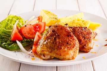 Grilled chicken thighs with boiled potatoes and vegetable salad 